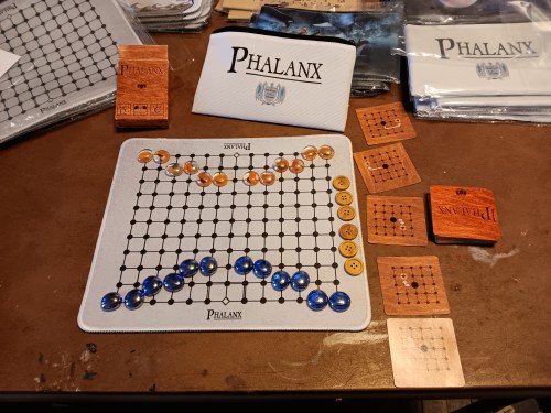 A rough test placement for the Phalanx mousepad edition with all the pieces laid out beside other parts of the merchandise order